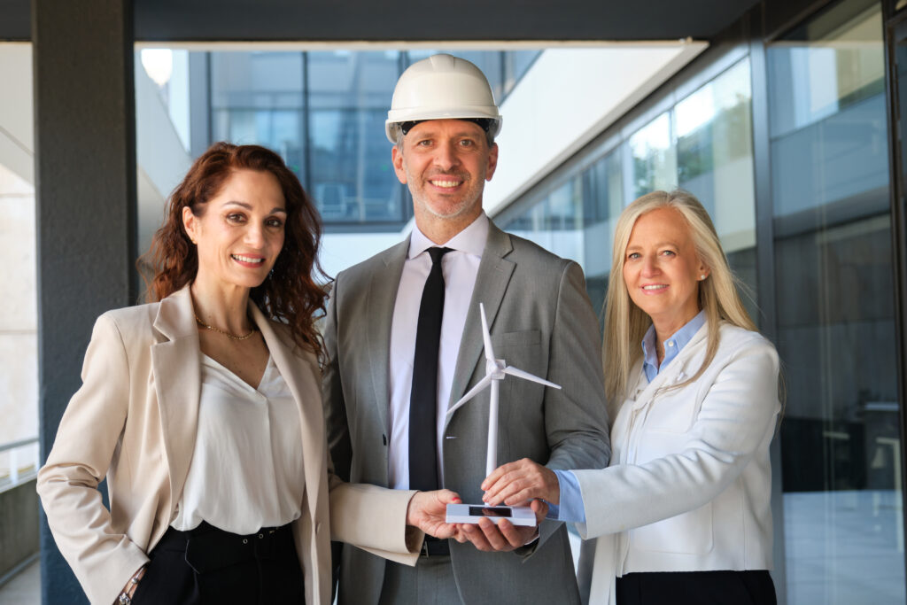Engineers showing a model of wind turbine and solar panel for renewable energy